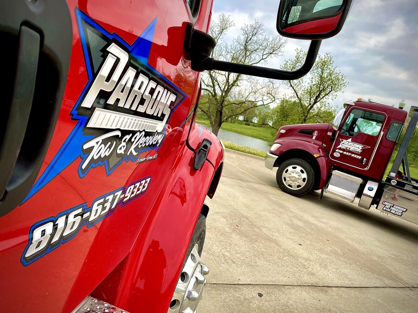 Close-up of the Parsons Tow & Recovery graphic and phone number on the Kenworth flatbed door